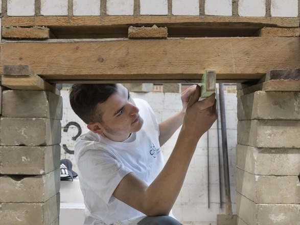 Ein Auszubildender im Bau-Handwerk bei der Arbeit